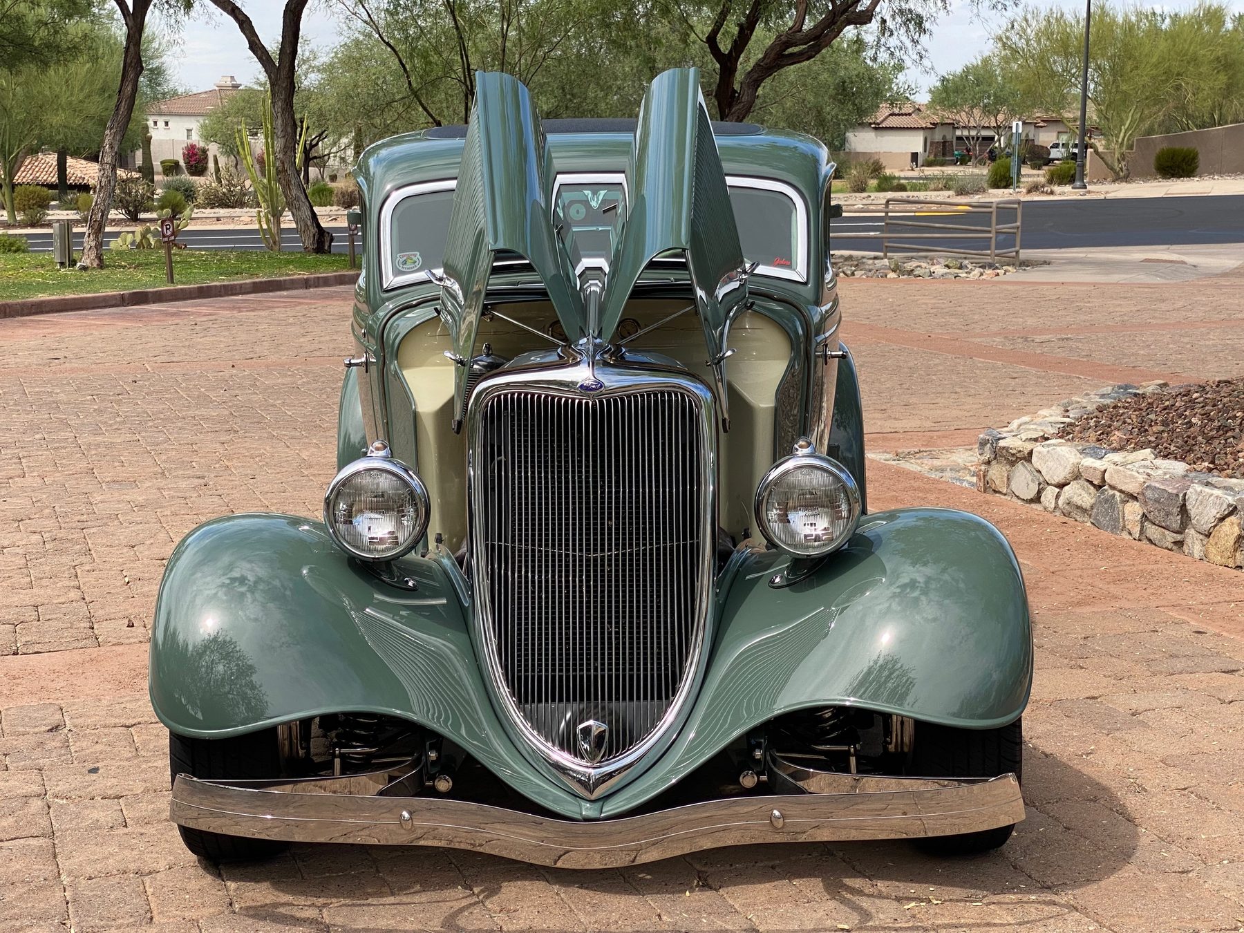 Head-on view with suicide doors open, showing cream interior and grille